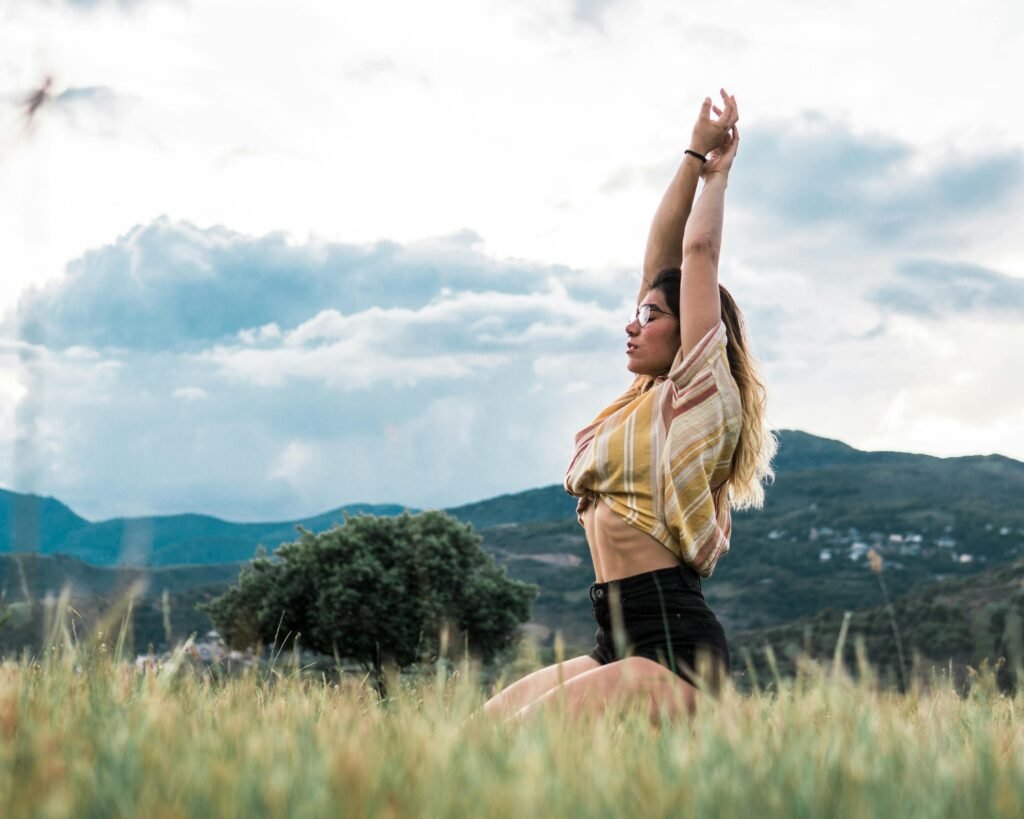 Woman in Yoga Position in Green Grass Field